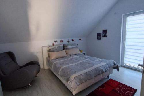 a bedroom with a bed and a chair and a window at NEU! FeWo Maria Buch in Neresheim