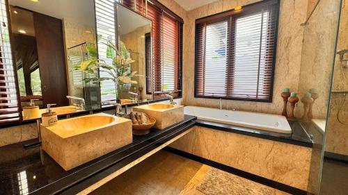 a large bathroom with two sinks and a bath tub at Luxury Balinese Pool Villa in Na Jomtien