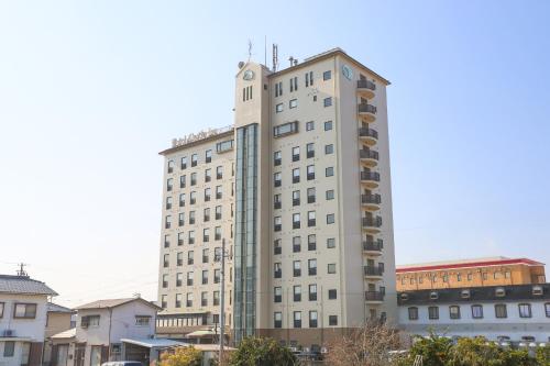 a tall white building with balconies on the side of it at Hotel Castle Inn Suzuka in Suzuka