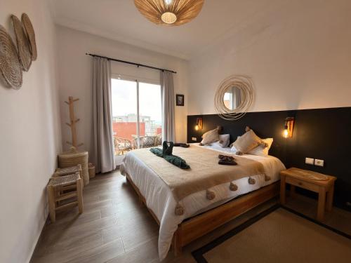 a bedroom with a large bed and a large window at Beldi Chic vue Mer - Taghazout in Agadir nʼ Aït Sa
