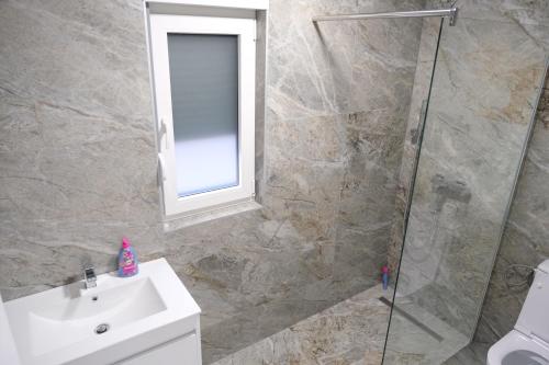 a bathroom with a shower and a sink and a mirror at Luxury Villa JAKOV in Banja Luka