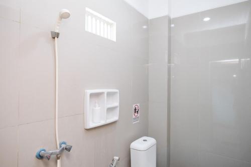 a bathroom with a shower and a toilet at Sans Salmas Mojokerto in Kranggan