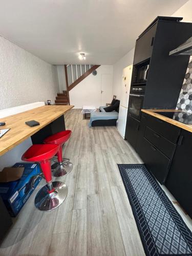 Duplex appartement في إتامب: مطبخ به طاولة وكراسي حمراء في غرفة
