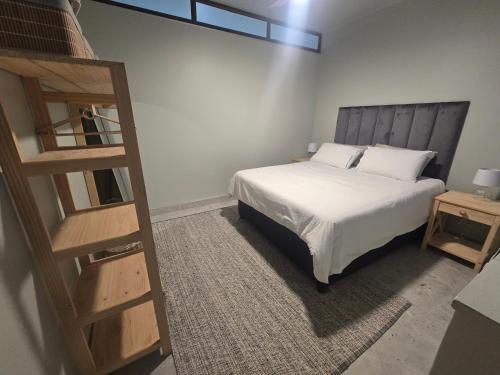 a bedroom with a bed and a wooden ladder at 407 Afsaal in Amanzimtoti