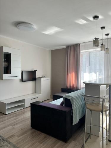 a bedroom with a bed and a table and a kitchen at Апартаменти студія in Truskavets