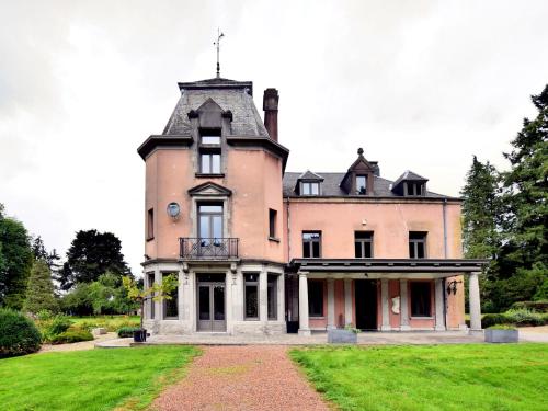 an old house with a turret on a grass field at Luxury Estate with Pool & Spa in Jamoigne