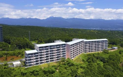 an aerial view of a building with mountains in the background at Scenery Resort Suruga in Numazu