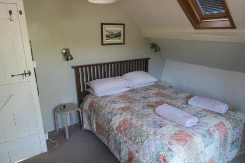 ein Schlafzimmer mit einem Bett und zwei Kissen darauf in der Unterkunft Welsh Hideaways in Pentre-briwnant