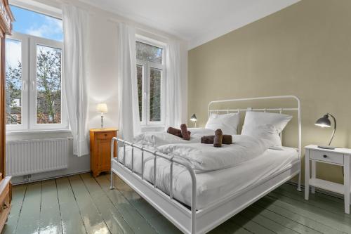 a bedroom with a white bed with teddy bears on it at BELETAGE in Emden