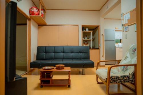 a living room with a couch and a table at Phuong`s house in Kiso