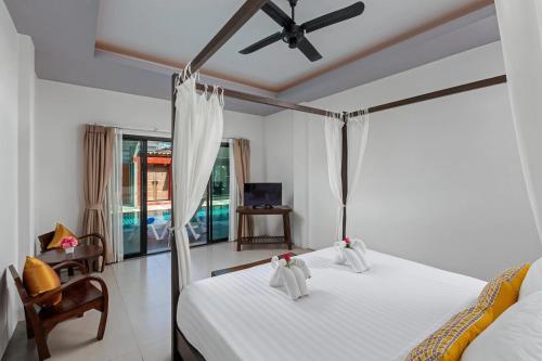 ein Schlafzimmer mit Bett und Deckenventilator in der Unterkunft Phuketa Hotel Phuket Town in Phuket