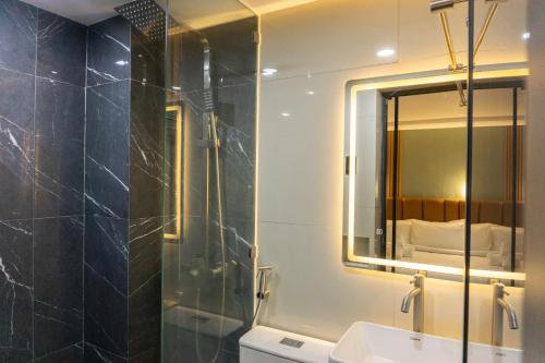 a bathroom with a shower and a sink and a mirror at Hotel Rodolfo in Tacloban