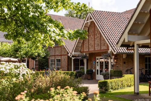 a house with a tiled roof at Landhuishotel De Bloemenbeek in De Lutte