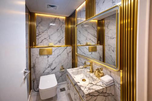 a bathroom with a sink and a toilet and a mirror at Marjan Island Beautiful Apartment Sea Side View Beach Luxury Rooms Ras Al Khaimah UAE in Ras al Khaimah