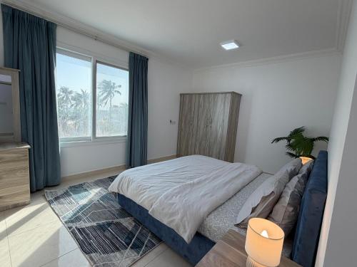 a bedroom with a bed and a large window at Beautiful Salalah Beach Apartments - 1 by Beautiful Salalah Tours in Salalah