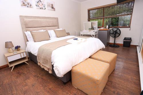 a bedroom with a large bed and a large window at African Oasis Morrocco in Somerset West