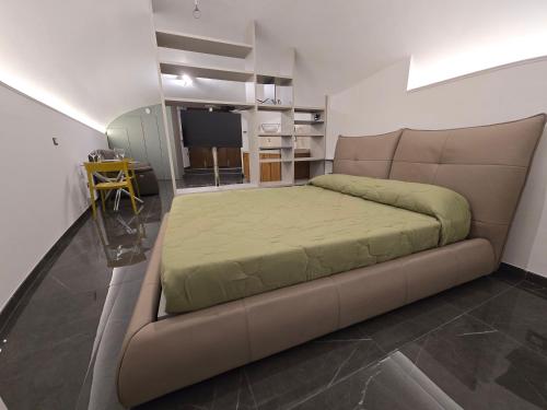 a large bed in a room with a couch at Dimora Di Davide in LʼAquila