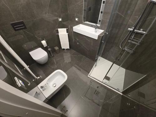 a bathroom with a sink and a toilet and a shower at Dimora Di Davide in LʼAquila