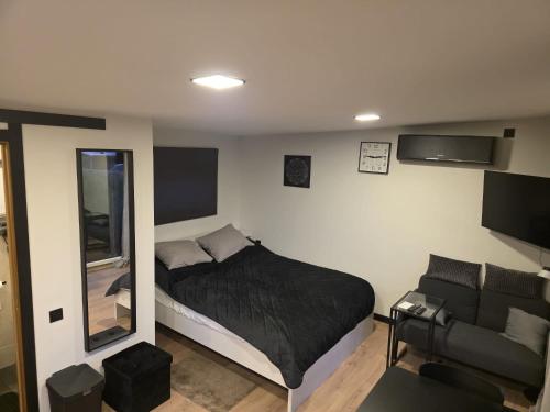 a small bedroom with a bed and a couch at Tīkli 3 in Bigauņciems