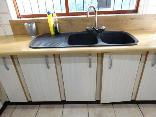 a kitchen counter with a sink and a window at African Oasis Morrocco in Somerset West