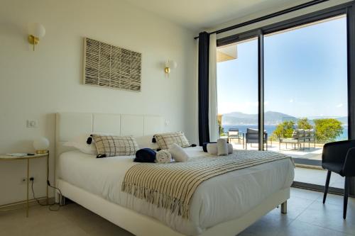 a bedroom with a large bed and a large window at VILLA IMPERIALE vue mer piscine in Pietrosella