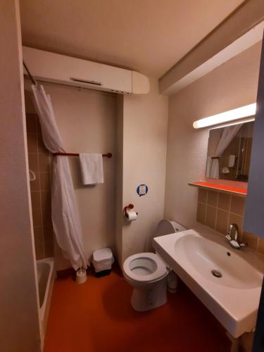 a bathroom with a white toilet and a sink at VVF Les Vosges Bitche in Bitche