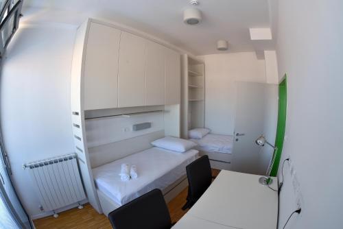 a small room with two beds and a table and chairs at SC Pula Rooms & Studio in Pula