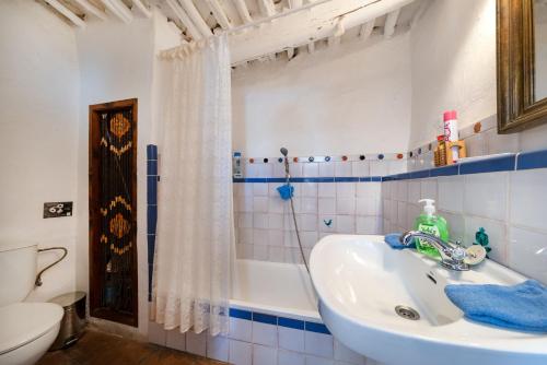 a bathroom with a sink and a tub and a toilet at El Gato Negro in Capileira