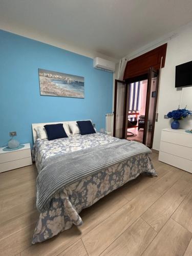 a bedroom with a large bed with a blue wall at Armonica Apartment in Castellammare di Stabia