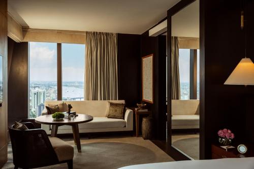 a living room with a couch and a table at Rosewood Phnom Penh in Phnom Penh