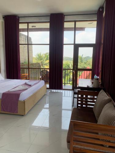 a bedroom with a bed and a balcony with windows at Cielstar Resort in Anuradhapura