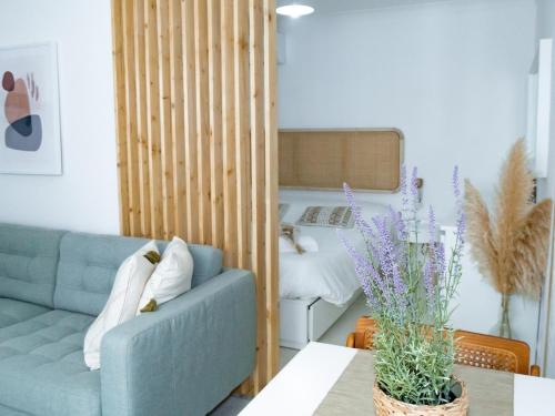 a living room with a blue couch and a bedroom at Alcácer do Sal Hideaway in Alcácer do Sal