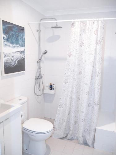 a bathroom with a shower curtain and a toilet at Alcácer do Sal Hideaway in Alcácer do Sal