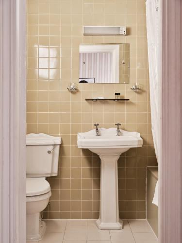 a bathroom with a toilet and a sink and a mirror at The Columbia in London