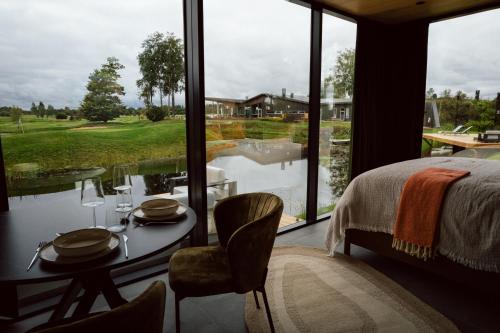 a bedroom with a bed and a table with a view at CR x Rae Golf in Suuresta