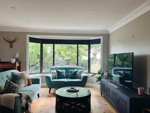 a living room with two couches and a tv at Casa Lonita - Indoor Pool & Spa in Beechworth