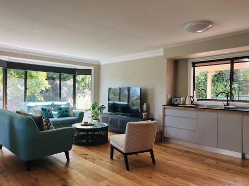 a kitchen and living room with a couch and a table at Casa Lonita - Indoor Pool & Spa in Beechworth