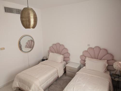 a bedroom with two beds and a mirror at Elegant Double Room in Abu Dhabi