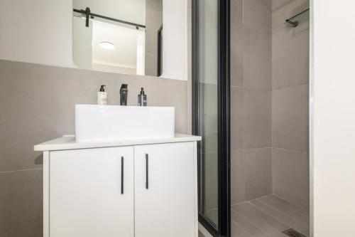a bathroom with a white sink and a shower at Durbanville Daydream in Durbanville