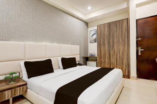 a bedroom with a large white bed with black pillows at Townhouse Hotel Sec- 54 Golf Course Road in Gurgaon