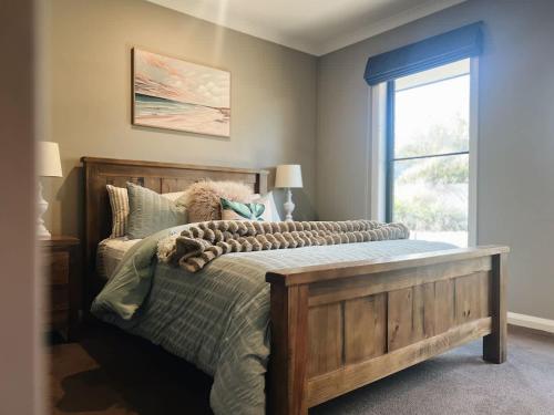 a bedroom with a wooden bed with a window at The Sunset Deck in Beechworth