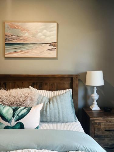 a bedroom with a bed with a picture on the wall at The Sunset Deck in Beechworth