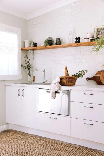 a kitchen with white cabinets and a sink at Miss Lucy Historic & Central in Beechworth