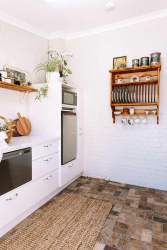 a kitchen with white walls and a counter top at Miss Lucy Historic & Central in Beechworth