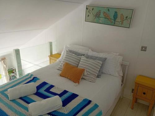 a bedroom with a bed with pillows on it at Tiny float home Brighton in Brighton & Hove