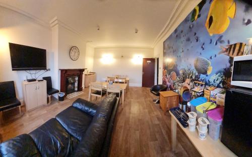 a living room with a leather couch and a table at Crittlewood Guest House in Morton