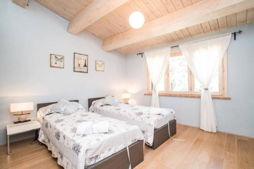 a bedroom with two beds and a window at Villa Cielo- Cignella Resort Tuscany Accommodation in Osteria Delle Noci