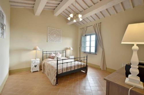 a bedroom with a bed and a window at Quercia Apartment - Cignella Resort Tuscany in Osteria Delle Noci