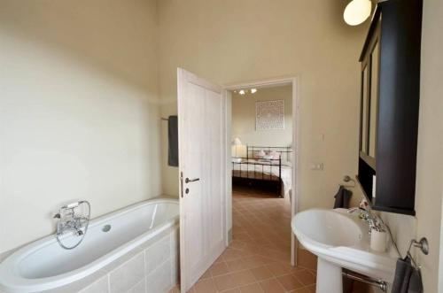 a bathroom with a tub and a sink and a bath tub at Quercia Apartment - Cignella Resort Tuscany in Osteria Delle Noci