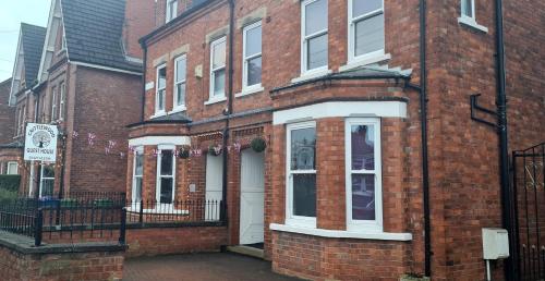 a red brick building with white doors and windows at Crittlewood Guest House in Morton